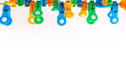 A group of multi-colored clothes pegs for domestic use, fixed on a stretched rope in an arbitrary position.