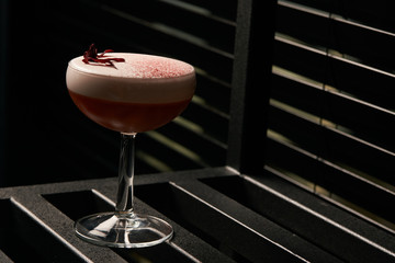 Classical Katana cocktail on table, close-up. Freshly cocktail with Rum, Passionfruit pure, Egg white, Sumax syrup, Ginger infuse. Sour-sweet, light, spicy alcoholic drink