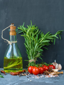 Rosemary oil. Selection of spices herbs. Ingredients for cooking. Food background on stone table.
