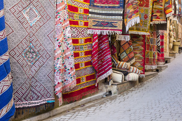 colored carpets with ornaments on the wall in old city in Morocco