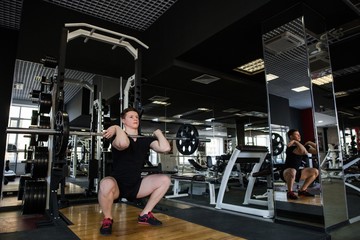Fototapeta na wymiar Training a bodybuilder in the gym lifting heavy weight