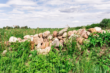 a small group of stones, a hill of stones overgrown with green grass, abstract background