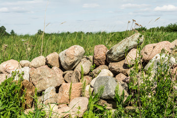 a small group of stones, a hill of stones overgrown with green grass, abstract background