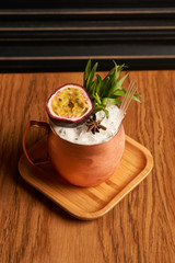 Spicy Mule cocktail on bar table. Alcoholic beverage drink with Rum angostura, reserve rum, dry orange passionfruit ,pure, pineapple pure, spice syrup ingredients, close-up