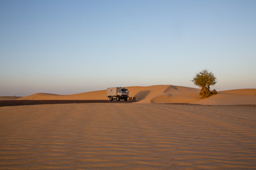 Fototapeta na wymiar Dune camp with 4x4 expedition verhicle at a beautful sand dune in the Sahara