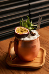 Spicy Mule cocktail on bar table. Alcoholic beverage drink with Rum angostura, reserve rum, dry orange passionfruit ,pure, pineapple pure, spice syrup ingredients, close-up