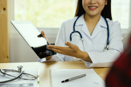 male medicine doctor explains to patient diagnosis pointing with tablets to x-ray picture,she working smart phone modern digital laptop computer graphics chart interface, healthcare