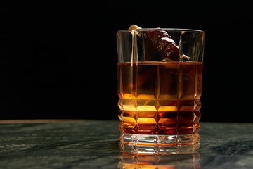 Artichoke Negroni cocktail on bar table. Tart, man's cocktail with Gin alcohol , Rosso, Cynar, close-up