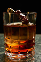 Artichoke Negroni cocktail on bar table. Tart, man's cocktail with Gin alcohol , Rosso, Cynar, close-up