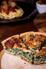 Quiche a savoury open tart  with spinach mushrooms cheese.