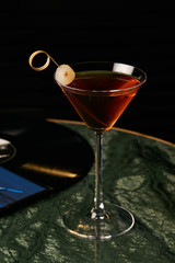 Vinyl Manhattan cocktail on bar table. Freshness Alcoholic beverage drink with whiskey, rosso, rosehip bitter, fernet branca menta ingredients, close-up