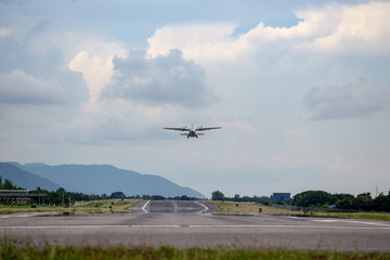 twin engines propeller aircraft take off from runway and climb with cloud and sky background