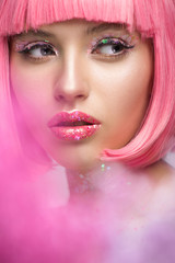 attractive woman with pink hair and makeup with glitter looking away