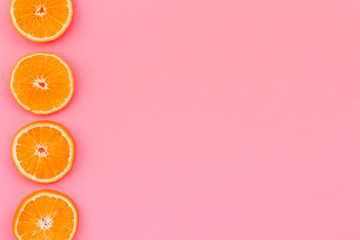 Citrus frame. Orange round slices composition on pink background top view copy space