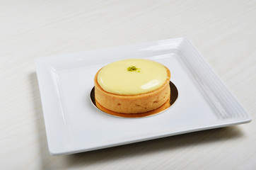 A slice of lemon tart on a plate 
