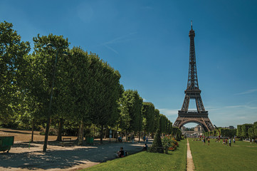 People, greenery and Eiffel Tower with sunny blue sky in Paris. Known as the “City of Light”, is one of the most awesome world’s cultural center. Northern France.