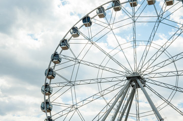 Fototapeta premium White fluffy clouds in deep blue sky, big Ferris wheel on sky background