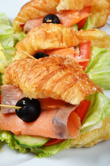  Smoked salmon croissants with salad on the plate