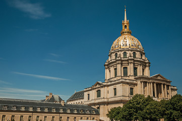 Obraz premium Trees in the gardens of Les Invalides Palace with the golden dome in a sunny day at Paris. Known as the “City of Light”, is one of the most impressive world’s cultural center. Northern France.