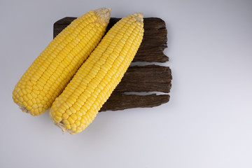 two raw corn on wood
