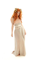 full length portrait of pretty red haired lady wearing fantasy toga gown, standing pose on white...