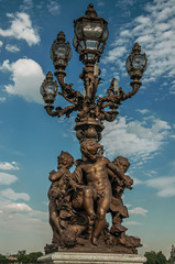 Close-up of the the lavishly decorated lamp on the Alexandre III bridge at the Seine river in Paris. Known as the “City of Light”, is one of the most awesome world’s cultural center. Northern France