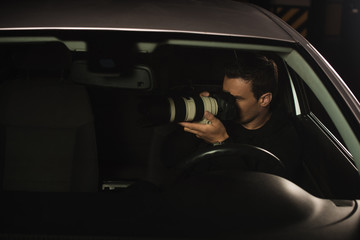 paparazzi doing surveillance by camera from his car