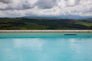 Fototapeta na wymiar swimming pool against beautiful landscape in Tuscany