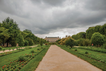 Path with building in the background and grassy wooded yard in the Garden of Plants in Paris. Known as the “City of Light”, is one of the most impressive world’s cultural center. Northern France.