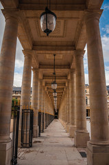 Pathway with marble colonnade between courtyards and cloudy sky at the Palais-Royal in Paris. Known as the “City of Light”, is one of the most impressive world’s cultural center. Northern France.