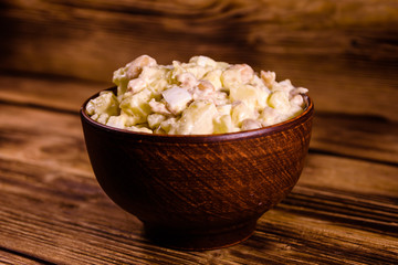 Salad with the haricot beans and meat dressed with mayonnaise in ceramic bowl