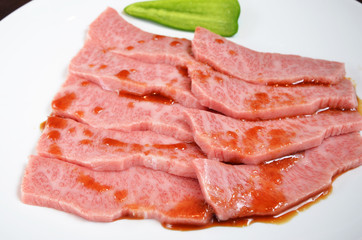 Thinly sliced beef on white plate