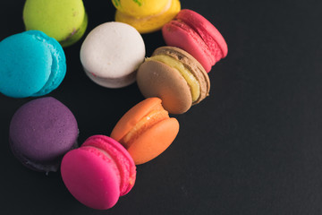 Macaroons on dark background, colorful french cookies macaroons.