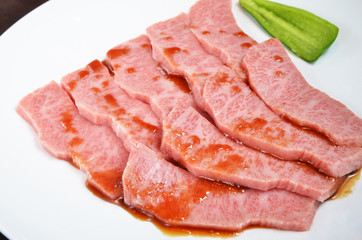 Thinly sliced beef on white plate