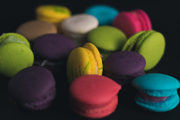 Macaroons on dark background, colorful french cookies macaroons.