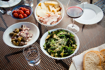 top view of mediterranean dishes: cheese, tomatoes, spinach, olives, sepia
