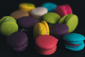 Fototapeta na wymiar Macaroons on dark background, colorful french cookies macaroons.