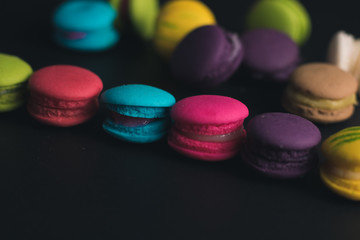 Obraz na płótnie Canvas Macaroons on dark background, colorful french cookies macaroons.