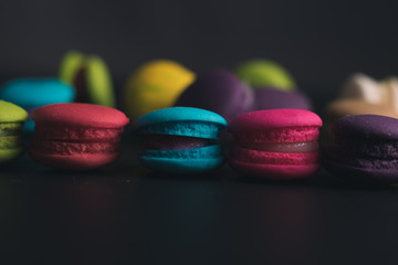 Macaroons on dark background, colorful french cookies macaroons.