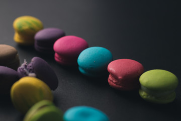 Fototapeta na wymiar Macaroons on dark background, colorful french cookies macaroons.