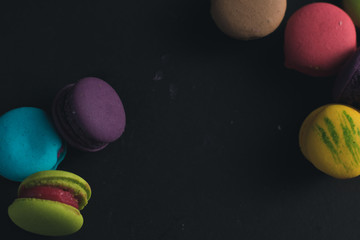Macaroons on dark background, colorful french cookies macaroons.