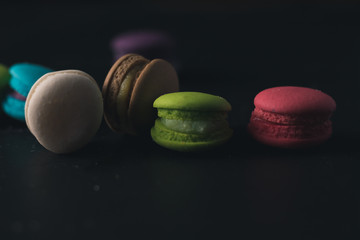 Macaroons on dark background, colorful french cookies macaroons.
