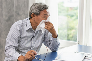 Asian Old man elder get sick from flu and runny nose when season change.