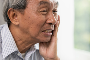 Asian Old man elder toothache pain suffer from dental problem teeth caries decayed tooth.