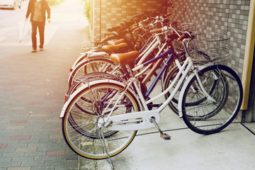 Naklejka na ściany i meble Bicycle parking in japan urban with blur man walking