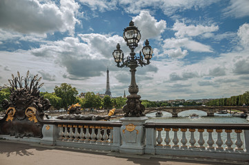 Golden statue and lighting post adorning the Alexandre III bridge over the Seine River and Eiffel Tower in Paris. Known as one of the most impressive world’s cultural center. Northern France.