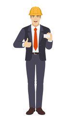 Businessman in construction helmet showing thumb up and showing the business card