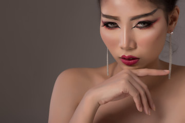 Portrait of beautiful asian girl  look at camera with creative art make up  on gray background.