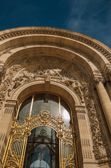 Close-up of the far-fetched golden gate and arch in a sunny day at the Petit Palais in Paris. Known as the “City of Light”, is one of the most impressive world’s cultural center. Northern France.