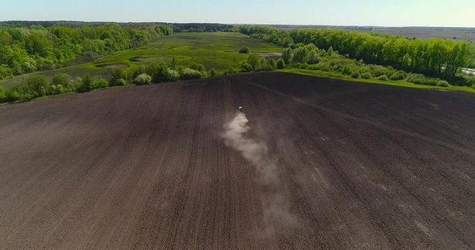 Aerial view of agricultural tractor cultivating field. Tractor At Work.